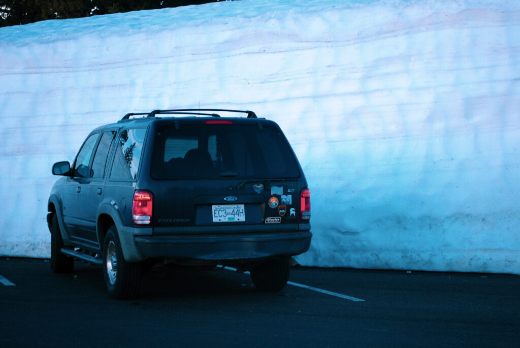 Car parked against a wall of snow in Crater Lake